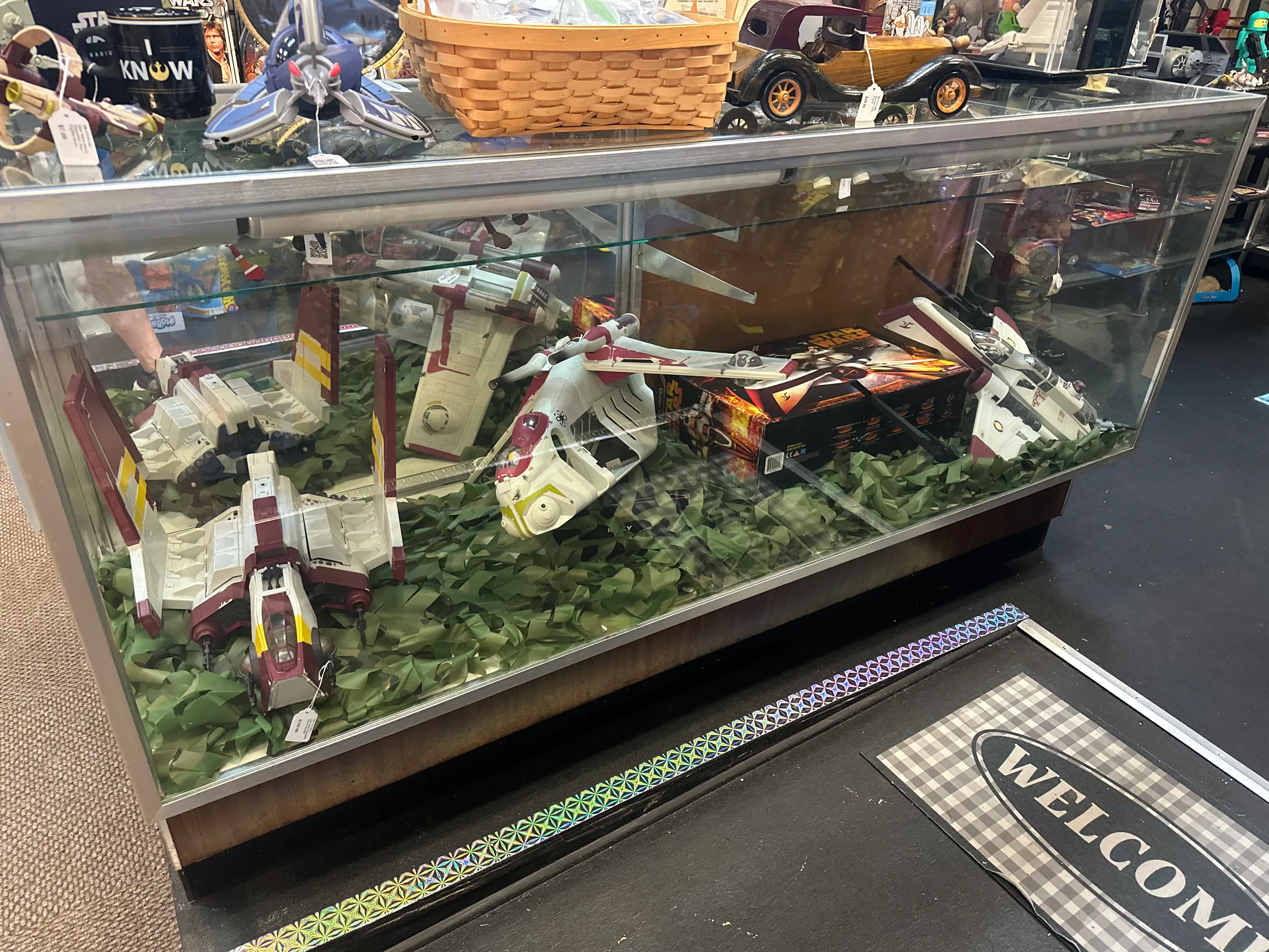 Large Star Wars vehicles arranged inside a glass display case