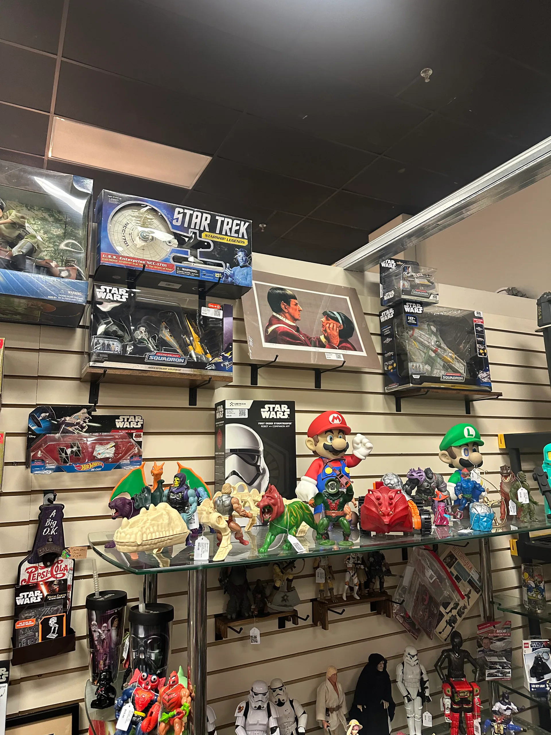 A tall booth display filled with Star Wars, Star Trek, Mario, and Masters of the Universe collectibles
