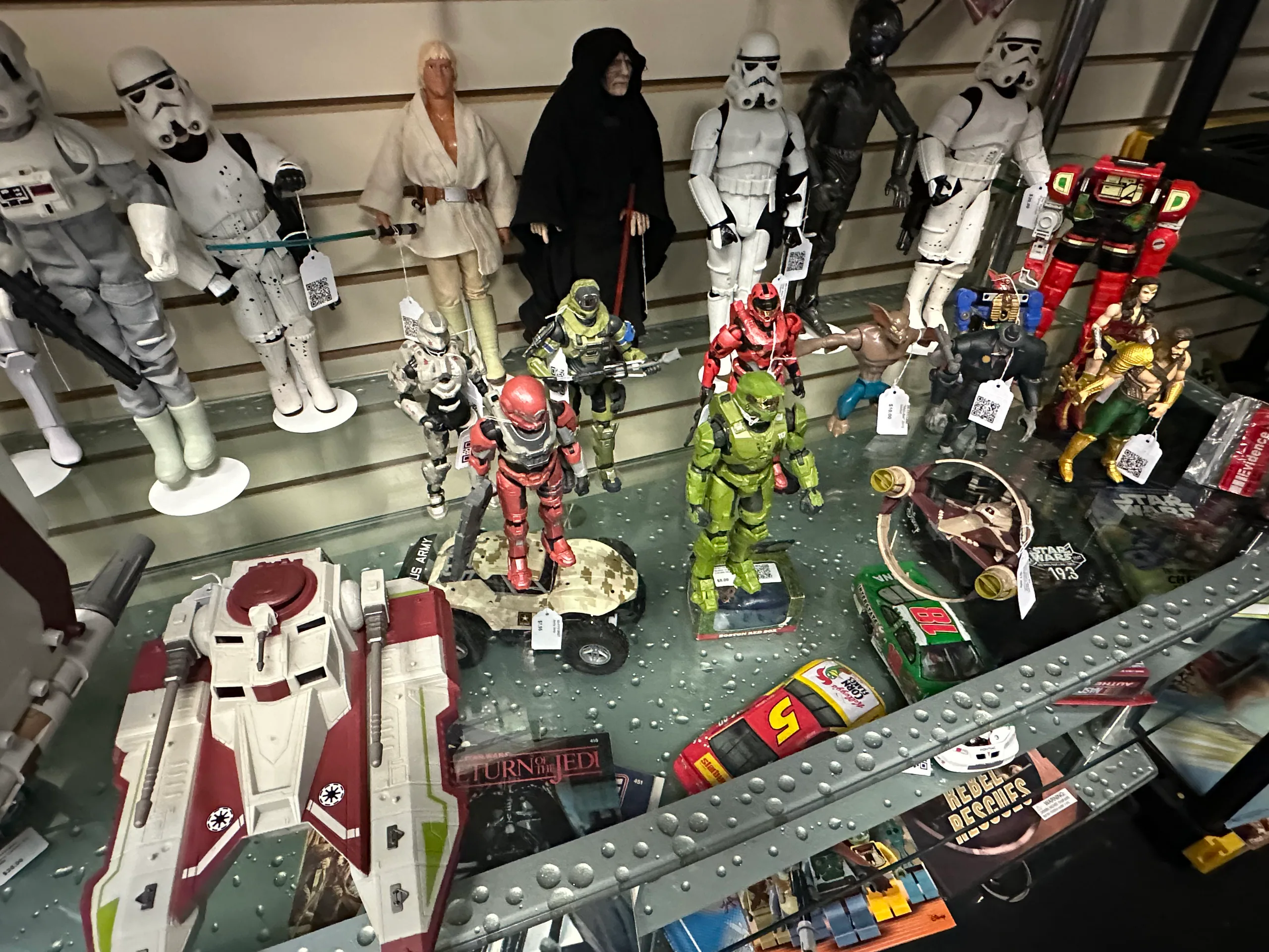 Star Wars, Halo, superhero, and other action figures arranged in a glass case