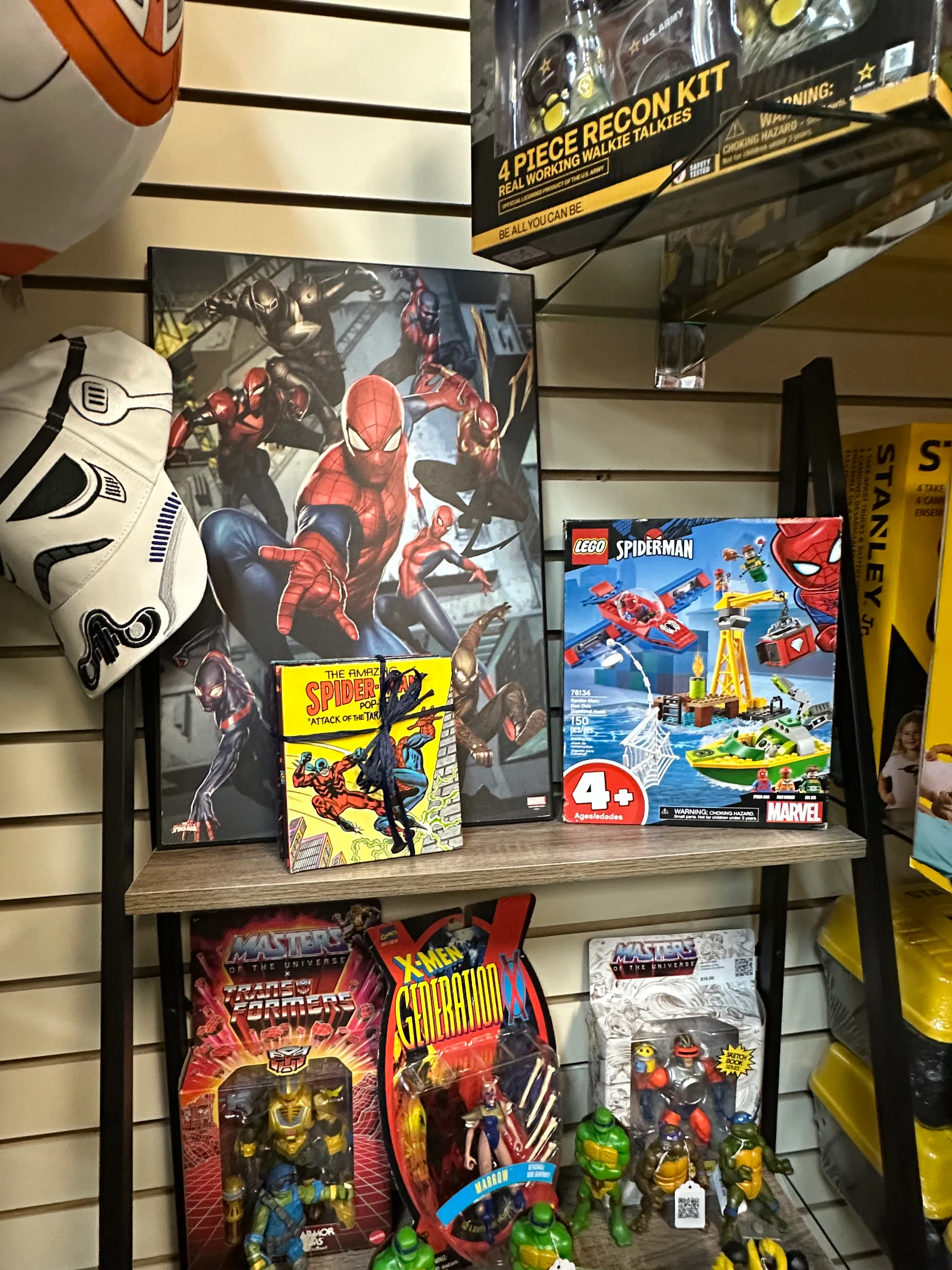 Marvel, LEGO, Transformers, X-Men, and Teenage Mutant Ninja Turtles collectibles arranged on booth shelves